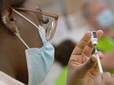 A pharmacist fills a syringe with a vial of the Pfizer COVID-19 vaccine at the Vaccine Village in Antwerp, Belgium. 