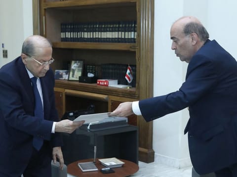 A handout picture provided by the Lebanese photo agency Dalati and Nohra shows Lebanese Foreign Minister Charbel Wehbe (right) presenting his resignation to President Michel Aoun at the Baabda presidential palace, east of Beirut on May 19, 2021.