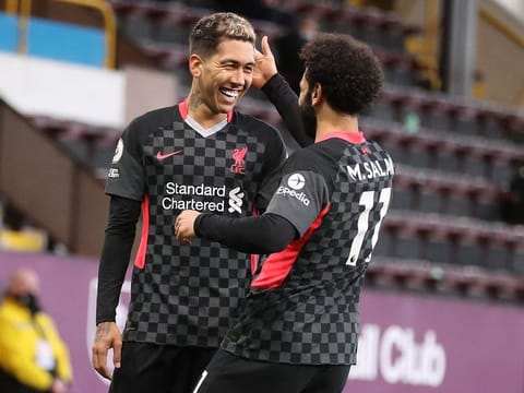 iverpool's Brazilian midfielder Roberto Firmino (L) celebrates scoring his team's first goal with Mohamed Salah.