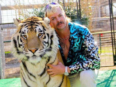 In this file photo taken on January 20, 2020 this undated photo courtesy of Netflix shows Joseph "Joe Exotic" Maldonado-Passage with one of his tigers. The US Justice Department said May 20, 2021 that it had seized 68 lions, tigers and lion-tiger hybrids as well as a jaguar from the former animal park of Joe Exotic, the star of the Netflix hit "Tiger King."