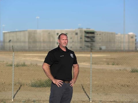 Aaron McGlothin, union president at the Federal Correctional Institution at Mendota, stands in front of the prison during a protest against staffing shortages, near the prison entrance in Mendota, Calif., Monday, May 17, 2021. 