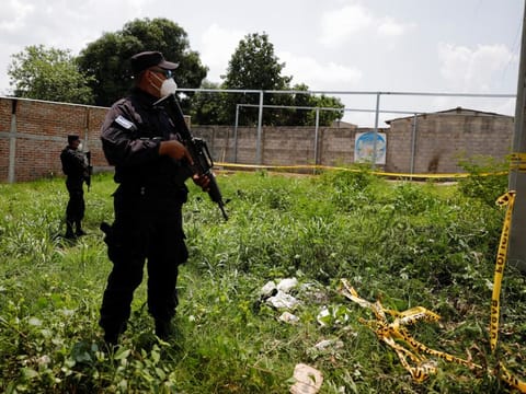 Police officers secure a news conference at the site where authorities are excavating a clandestine cemetery discovered at the house of a former police officer and containing many bodies, most of them believed to be women in Chalchuapa, El Salvador May 20, 2021. 