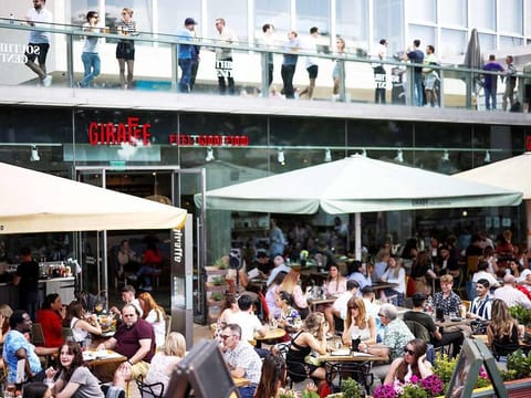 People sit at an outdoor restaurant on the South Bank during sunny weather, in London, on June 5, 2021. 