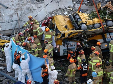 South Korean rescue workers search for possible survivors from the debris of a collapsed building in Gwangju on June 9, 2021