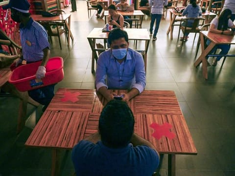 People eat a meal at a food court in Select City Mall after authorities eased a lockdown imposed as a preventive measure against the COVID-19 coronavirus, in New Delhi on June 19, 2021. 