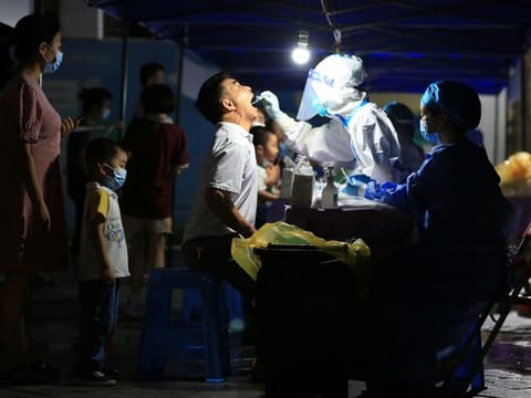 A medical worker collects a swab from a man in Xiangzhou district of Zhuhai, following COVID-19 outbreak in Guangdong province, China.