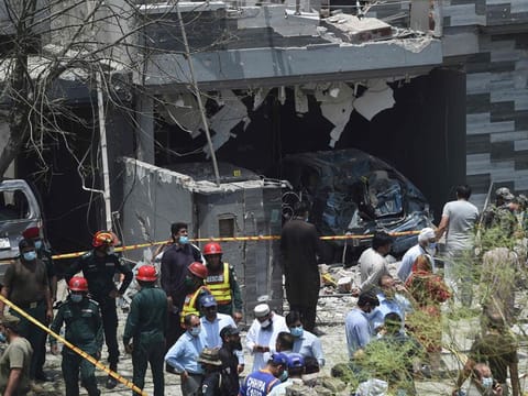 Security officials inspect the site of an explosion in Pakistan's eastern city of Lahore on June 23, 2021. 
