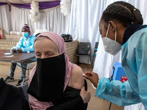 A teacher receives the single-dose Johnson & Johnson COVID-19 vaccine from a healthcare worker at Roshnee Civic Centre, south of Johannesburg, South Africa, Wednesday, June 23, 2021, during rollout of teacher vaccinations programme. 