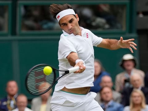 Switzerland's Roger Federer returns the ball to Italy's Lorenzo Sonego on day seven of the Wimbledon Tennis Championships in London, Monday, July 5, 2021. 