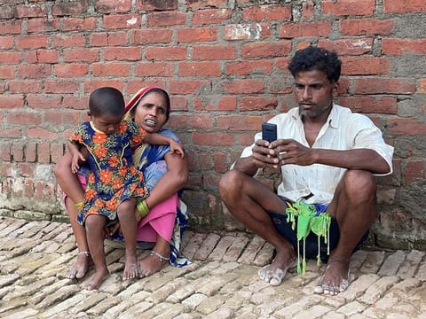Asha Devi, 35, a mother of five who is a labour worker, sits along with her husband and their daughter outside her one-room house in Dihwa village in the northern state of Uttar Pradesh. 