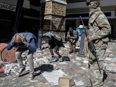  South Africa National Defence Force (SANDF) soldiers and South African Police Service officers detain suspected looters at Jabulani Mall in Soweto on July 13, 2021.  South Africa's army said that it was deploying troops to two provinces, including its economic hub of Johannesburg, to help police tackle deadly violence and looting as unrest sparked by the jailing of ex-president Jacob Zuma entered its fourth day. 