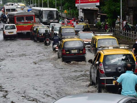 Vehicles make their way through a waterlogged street after heavy rainfall, in Mumbai on Sunday,  July 18.  