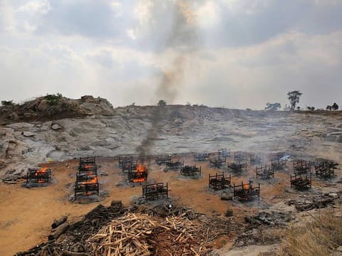 In this May 5, 2021, file photo, funeral pyres of 25 COVID-19 victims burn at an open crematorium set up at a granite quarry on the outskirts of Bengaluru, India. India's excess deaths during the pandemic could be a staggering 10 times the official COVID-19 toll, likely making it modern India's worst human tragedy, according to the most comprehensive research yet on the ravages of the virus in the south Asian country. 