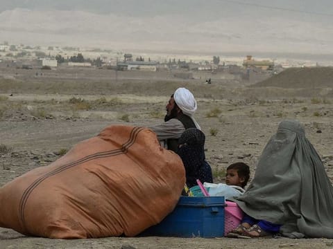 Stranded people wait for the reopening of border crossing point in Pakistan's border town of Chaman on July 16, 2021, following clashes between Afghan forces and Taliban fighters in Spin Boldak to retake the key border crossing with Pakistan. 