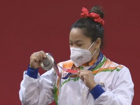 Indian weightlifter Mirabai Chanu admires her silver medal in the 49 kg class in Tokyo on Saturday.
