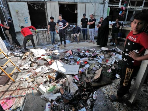 Iraqis inspect the site of the explosion in a popular market in the Shiite-majority Sadr City neighbourhood, east of the capital Baghdad on July 20, 2021. Iraq was in mourning for at least 36 people killed when a bomb ripped through a crowded Baghdad market in what the Daesh group' claimed as a suicide attack. 