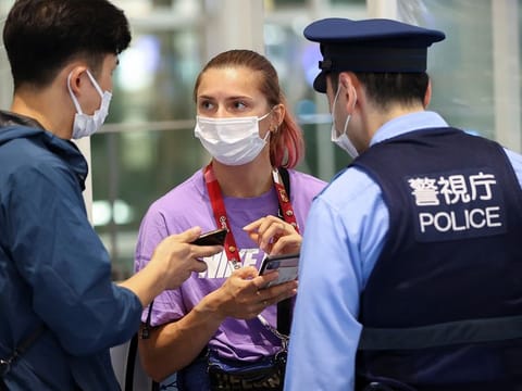 Belarusian athlete Krystsina Tsimanouskaya talks with a police officer at Haneda international airport in Tokyo, Japan August 1, 2021. 