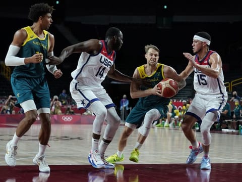 Australia's Nathan Sobey (9) second right, drives between United States's Devin Booker (15), right, and United States's Draymond Green (14) during men's basketball semifinal game at the 2020 Summer Olympics.