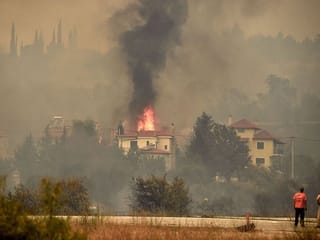 Photos: Thousands flee as wildfires rage through Greece