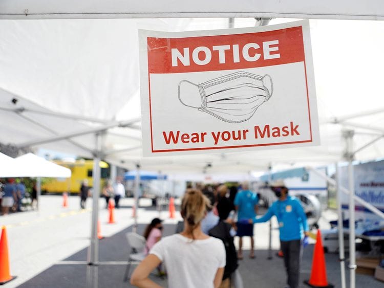 Patients wait in line to get a swab test