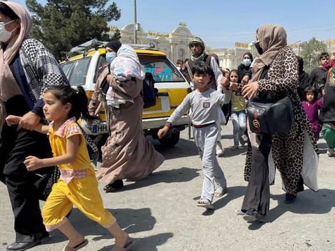 Women with their children try to get inside Hamid Karzai International Airport in Kabul, Afghanistan August 16, 2021.