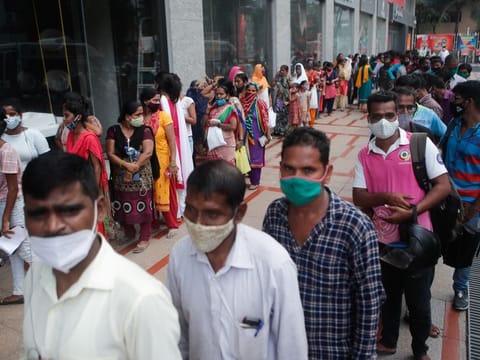 People wait in a queue to receive the vaccine outside a shopping mall in Mumbai.