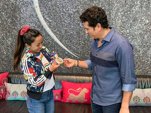 Tokyo Olympics silver medallist weightlifter Saikhom Mirabai Chanu shows her medal to cricket legend Sachin Tendulkar 