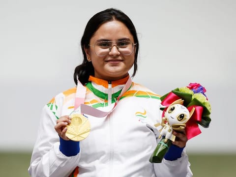 Gold medallist Avani Lekhara of India celebrates on the podium. 