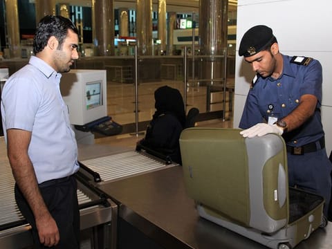 A Dubai Customs official checks a piece of baggage.
