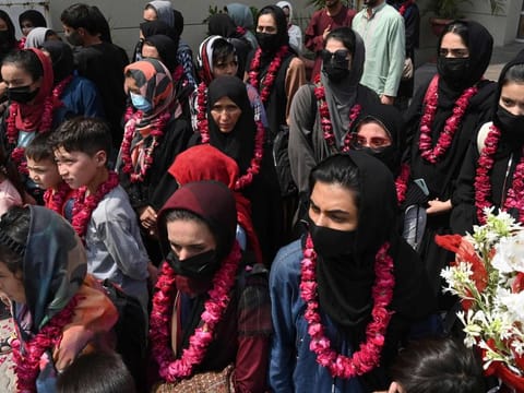 Afghanistan's national girls football team arrive with their family members at the Pakistan Football Federation (PFF) in Lahore on September 15, 2021 