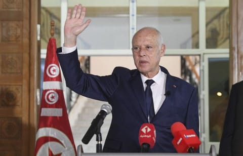 Tunisian President Kais Saied waves to Tunisian citizens as he delivers a speech during his visit to Sidi Bouzid, Tunisia, on September 20, 2021. 