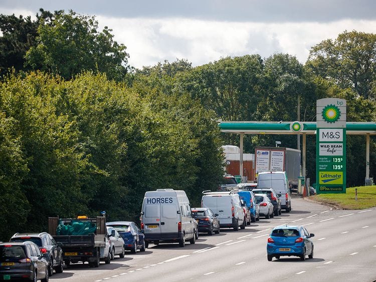 Cars queue up to use the fuel pumps at BP Plc petrol station near Guildford
