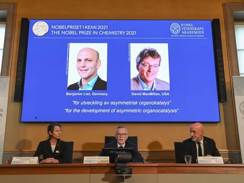 Member of the Nobel Committee for Chemistry Pernilla Wittung Stafshede, Goran K Hansson, Secretary General of the Royal Swedish Academy of Sciences and member of the Nobel Committee for Chemistry Peter Somfai address a press conference to announce the winners of the 2021 Nobel Prize in Chemistry (On display) Germany's Benjamin List (left) and David MacMillan of the United States, at the Royal Swedish Academy of Sciences in Stockholm, Sweden, on October 6, 2021. 