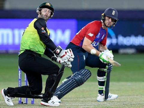 England's Jos Buttler plays a shot as Australia's wicketkeeper Matthew Wade watches during the ICC Men’s Twenty20 World Cup cricket match at the Dubai International Cricket Stadium on October 30, 2021.