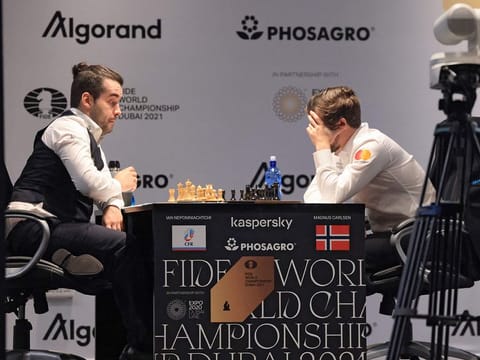 Magnus Carlsen (right) and Ian Nepomniachtchi contemplate their moves in their third game in Dubai on Sunday.