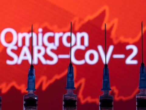 Syringes with needles are seen in front of a displayed stock graph in the illustration taken on November 27, 2021. 