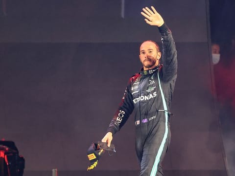 Mercedes' British driver Lewis Hamilton waves from the podium after winning the Formula One Saudi Arabian Grand Prix at the Jeddah Corniche Circuit in Jeddah on December 5, 2021. 