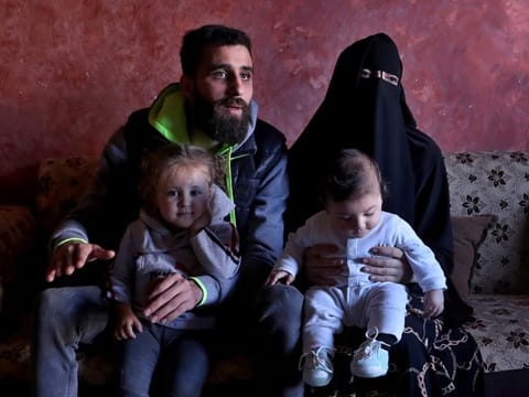 Ziad Khaled Hilweh, 23, who tried to migrate to Europe with his family, speaks during an interview as he sits with his wife Alaa Khodr, 22, his daughter Jana 2 year-old and his son Karim 3 months, at his parents house in the northern city of Tripoli, Lebanon, Monday, Dec. 6, 2021. Lebanese are setting off from the port city of Tripoli to attempt the perilous journey by boat to Cyprus and beyond in the hopes of reaching Europe. 
