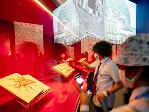 Students study the pages of famous date archives on display at the France Pavilion