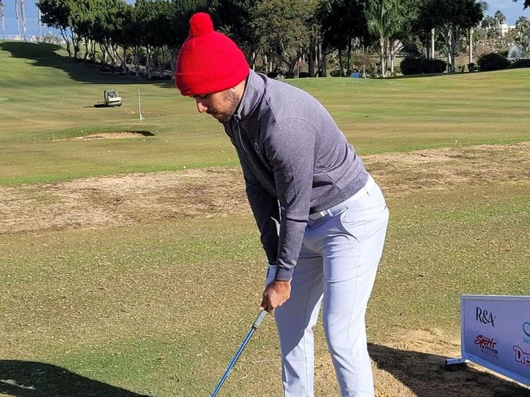 UAE's Ahmed Skaik wrapped up against the elements on the driving range at Dreamland Golf Resort, Cairo