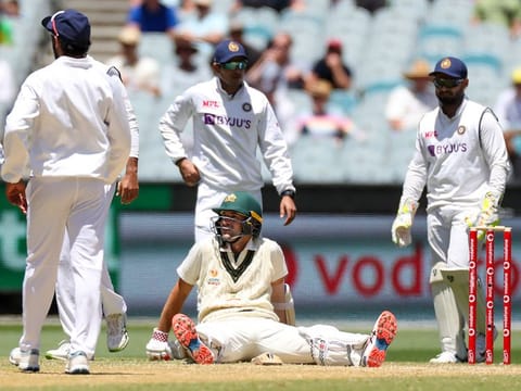 Australia's Joe Burns sits on the pitch as he awaits a video review during play on day three of the second cricket test between India and Australia at the Melbourne Cricket Ground. 