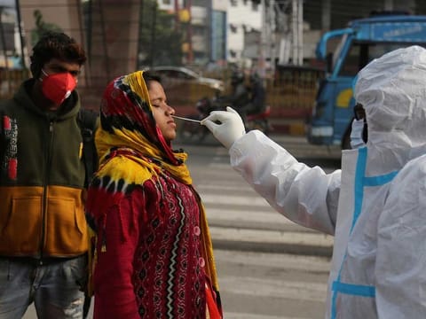 A health worker collects a swab sample from a woman to test for COVID-19 in Jammu last month. India recorded the second highest number of cases globally after the US, but the number of cases have been on a downward spiral since reaching the 'peak' in September.