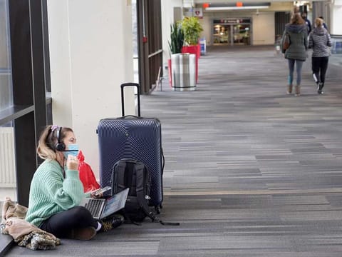 Katelyn Darrow gets some work done on her laptop as she waits to board her flight at the Philadelphia International Airport Friday on December 31, 2021, in Philadelphia. Winter weather and crew members infected with COVID-19 have forced airlines to spike thousands of US flights over the past week, complicating travel plans for many people during the busy holiday season. 