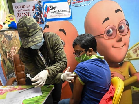 A health worker inoculates a youth with a dose of the Covaxin during a vaccination drive for those in the 15-18 age group in New Delhi on January 4, 2022. 