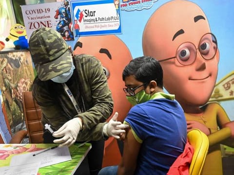 A health worker inoculates a youth with a dose of the Covaxin during a vaccination drive for those in the 15-18 age group in New Delhi on January 4, 2022. 