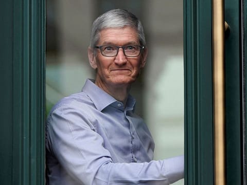 Apple Chief Executive Officer Tim Cook watches customers awaiting the grand opening of the new Apple Carnegie Library store in Washington, U.S., May 11, 2019.  
