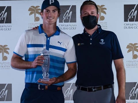 Cian Hurley, Director of Golf at Emirates Golf Club, presents Monty Scowsill with the Emirates Amateur Open trophy 