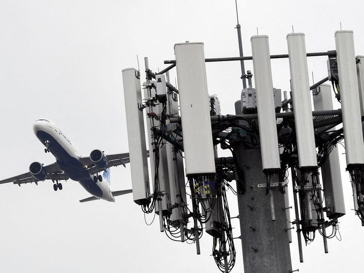 A cellular tower stands as an JetBlue Airbus A321neo airplane lands at Los Angeles