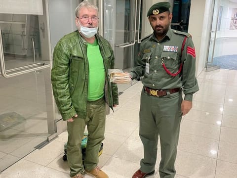A Dubai Police officer hands over the lost cash to its owner, Siegfried Tellbach - a traveller from Germany. 