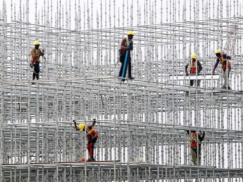 Construction workers seen on scaffolding for a bridge made for the coastal road project at Hajji Ali in Mumbai. India is focusing on infrastructure investments to bolster industrial demand 